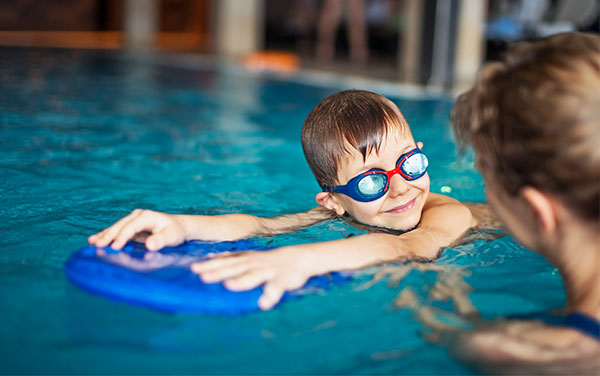 Child with swim teacher in pool.