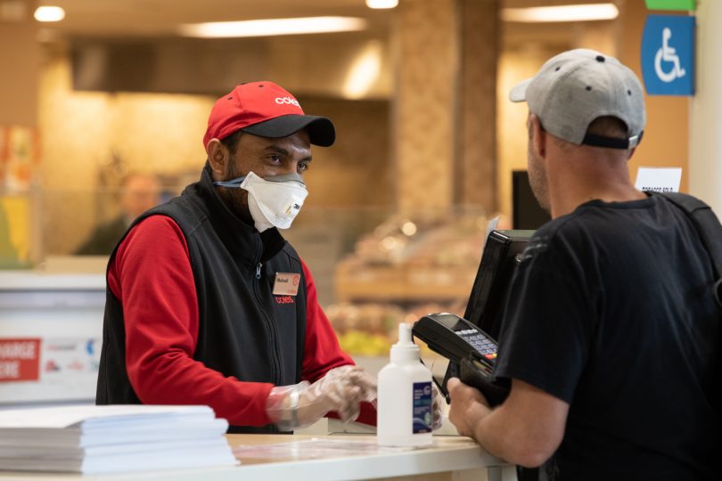 Supermarket employee with mask and gloves