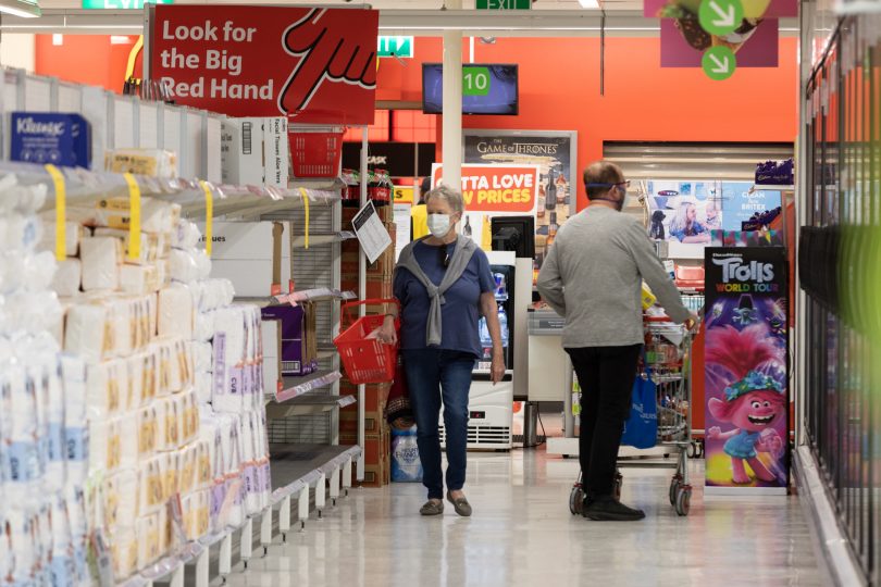 Supermarket shoppers with masks on.