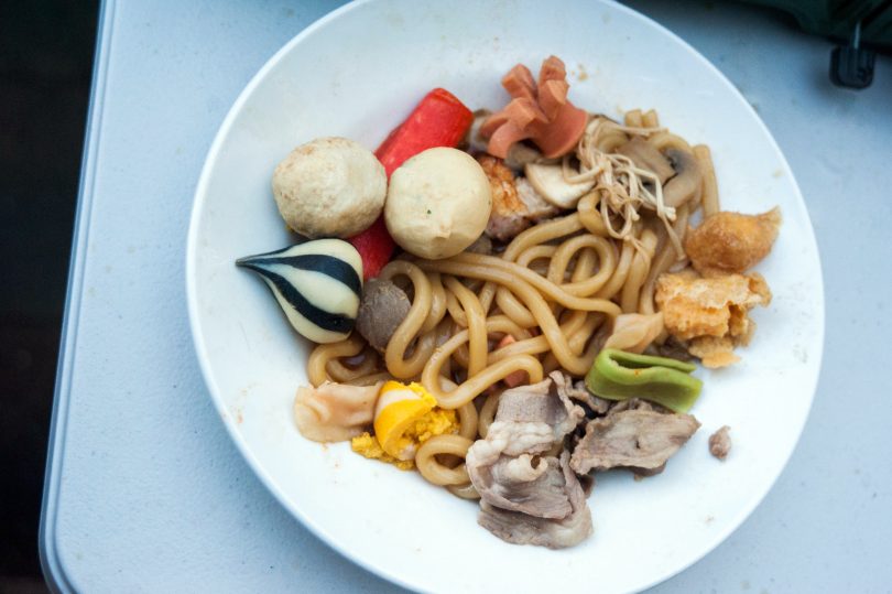 Plate of food with noodles, meat, tofu and mushrooms.