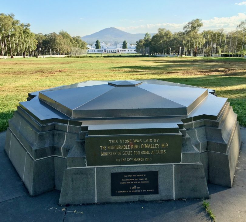 Canberra's foundation stone with Old Parliament House in background.