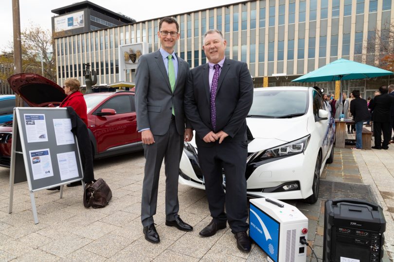 Two men in front of electric cars