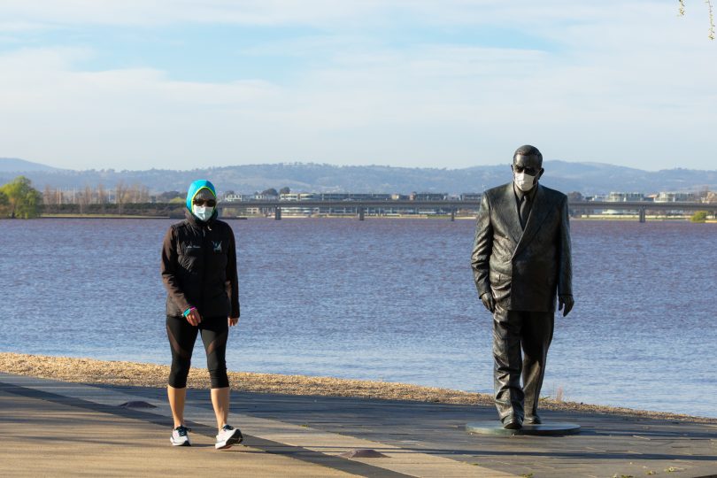 Woman walking along Lake near Sir Robert Menzies statue.