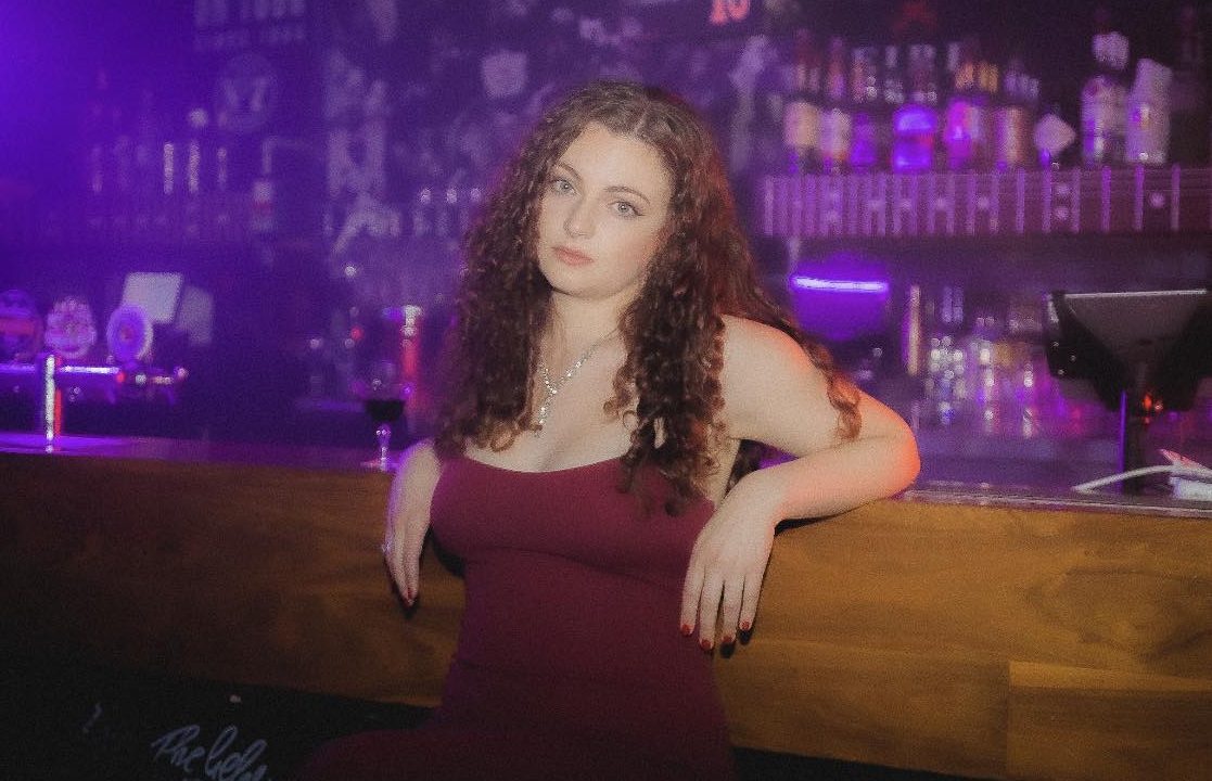 Gia Ransome leaning against a bar