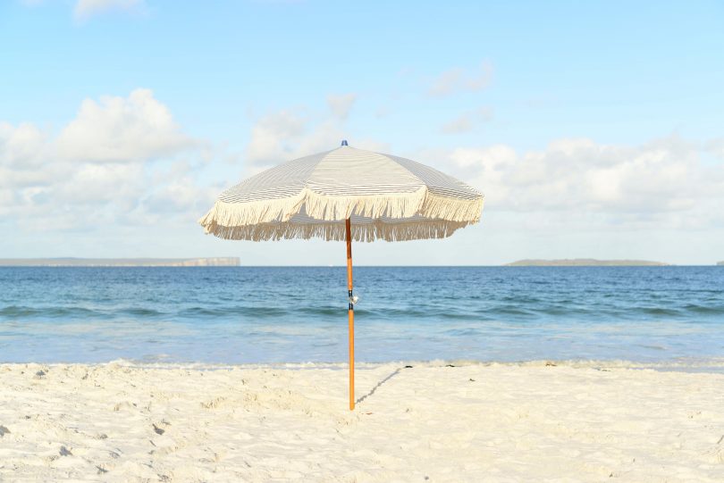 Umbrella in sand on deserted NSW South Coast beach.